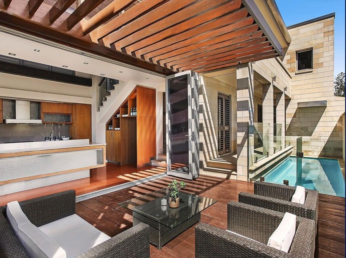 Covered outdoor entertaining area beside a pool
