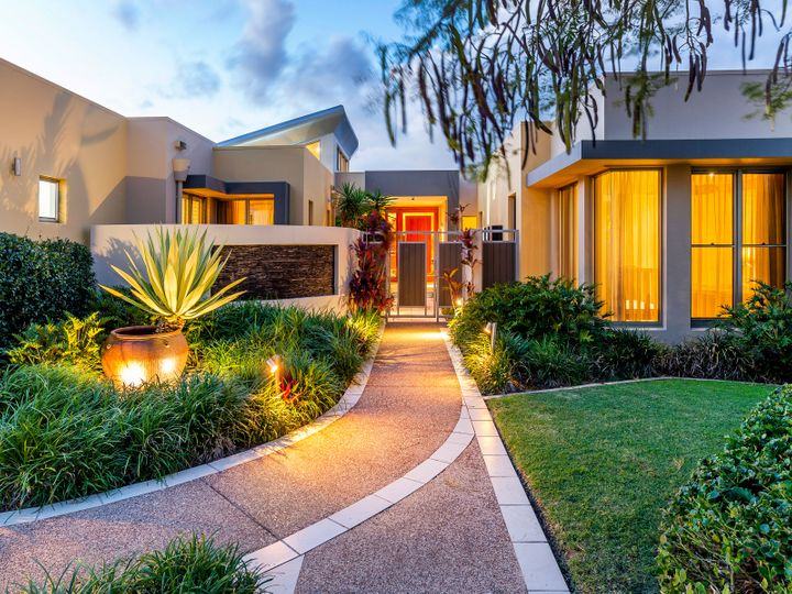 A welcoming, freshly landscaped front entry at dusk
